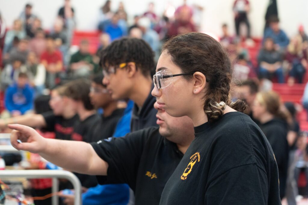 Team 271 Mechanical Marauders students and robot at competitions and in the shop