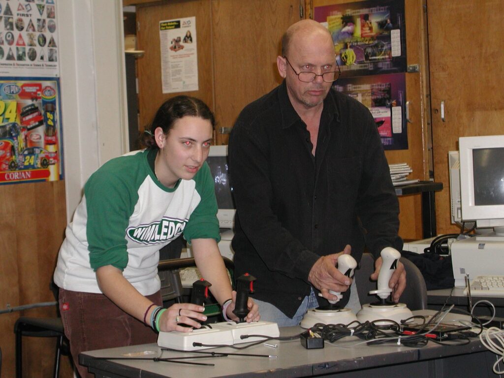 Pete Burke driving a robot with a student, 2004