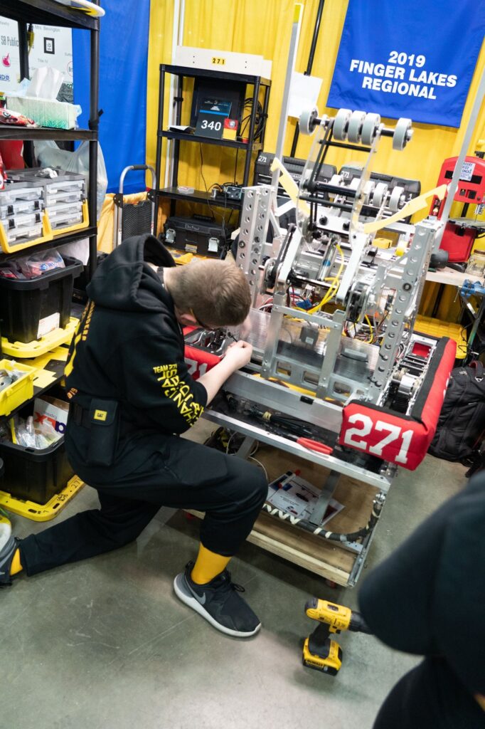 Team 271 robot in the Championship pit under the 2019 Finger Lakes Regional Winner banner